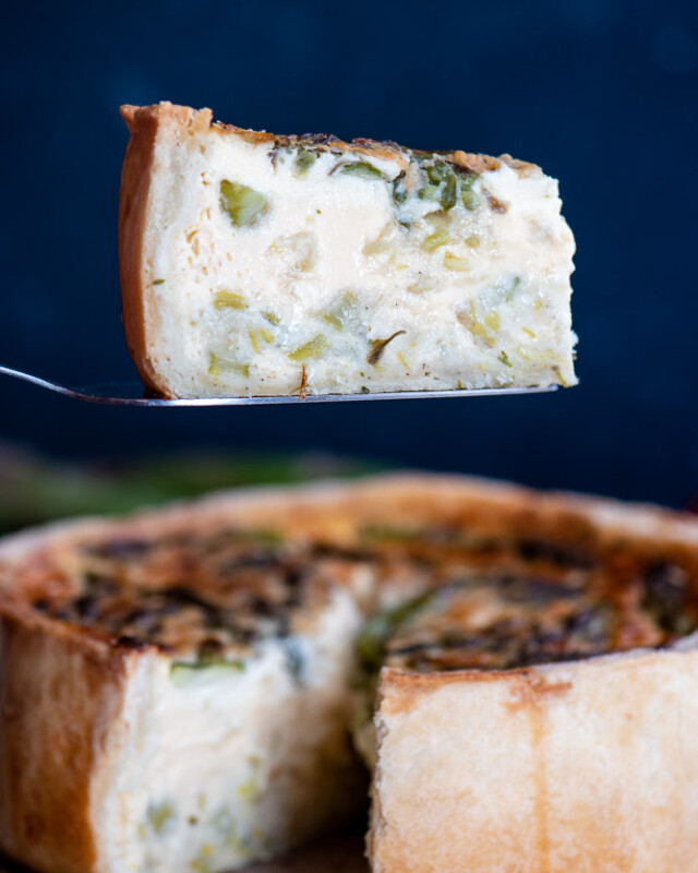 Slice of asparagus and leek quiche with a creamy egg custard and crisp shortcrust pastry.
