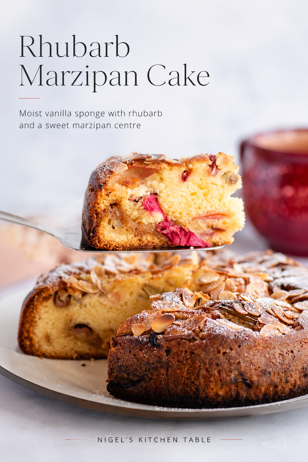 Rhubarb marzipan cake with tender pink rhubarb, a sweet almond marzipan layer and flaked almonds, shown with a slice lifted from the cake.