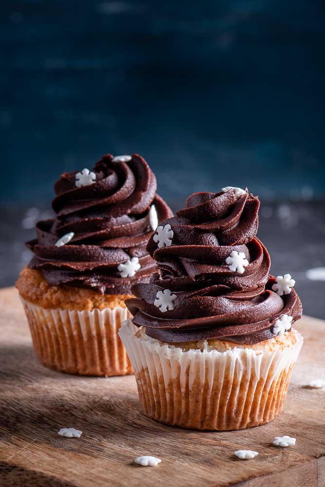 Vanilla buttercream piped in a tall swirl on top of a cupcake.