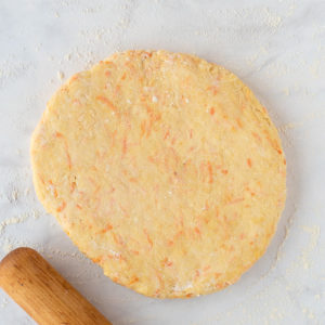 Tahini and carrot scone dough rolled into a thick circle ready for cutting.